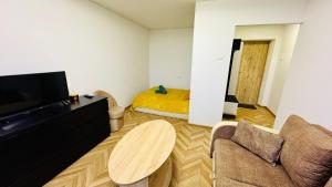 a living room with a couch and a table at Light of Happiness in Anykščiai