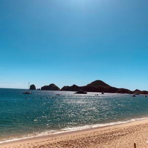 una spiaggia con l'oceano e le montagne sullo sfondo di Medano Beach front resort Cabo Villa 2Queen beds 2805-B a Cabo San Lucas