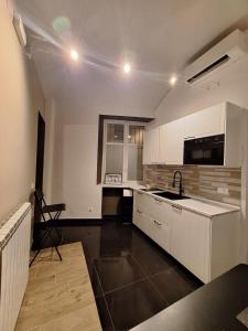 a kitchen with white cabinets and a sink at Smarthome Suites Centro Storico Collegno in Collegno