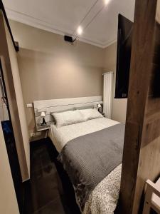 a bedroom with a bed and a flat screen tv at Smarthome Suites Centro Storico Collegno in Collegno