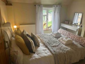 a bedroom with a bed with pillows and a window at Bridle Cottage in Pentrich