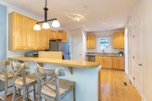 a kitchen with wooden cabinets and a island with bar stools at The Goat Locker in Annapolis