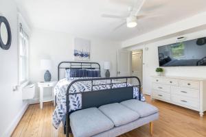a white bedroom with a bed and a tv at The Goat Locker in Annapolis