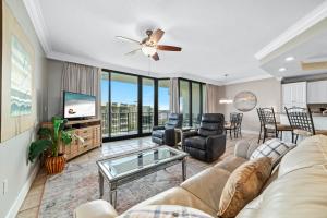 a living room with a couch and a tv at Phoenix on the Bay 1514 in Orange Beach