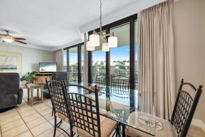 a dining room and living room with a glass table at Phoenix on the Bay 1514 in Orange Beach