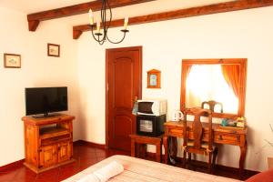 a bedroom with a bed and a desk with a television at Hotel Las Cañadas in La Esperanza