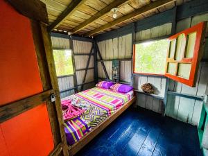 a bed in the inside of a tiny house at hostal herping bahia solano tour in El Valle