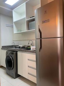 a kitchen with a stainless steel refrigerator and a washing machine at Centro, Ar Cond, WI-FI and Lava e Seca in Santa Maria +2 photos