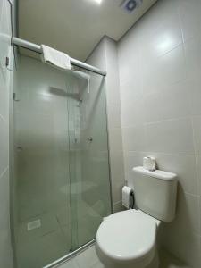 a bathroom with a toilet and a glass shower at Centro, Ar Cond, WI-FI and Lava e Seca in Santa Maria