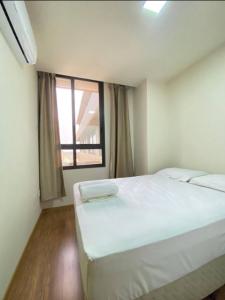a bedroom with a large white bed and a window at Centro, Ar Cond, WI-FI and Lava e Seca in Santa Maria