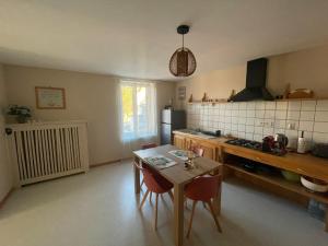 a kitchen with a table and chairs in a room at Murmure de la Forêt in Bains-les-Bains