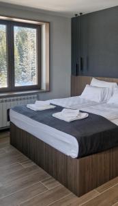 1 cama grande con 2 toallas encima en Nova Planina Jahorina, en Jahorina