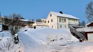 a pile of snow in front of a house at Tromsø apartment near the university in Tromsø