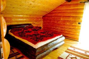 a bedroom with a bed in a wooden room at Hanul Prislop in Statiunea Borsa