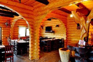 a dining room with an archway in a log cabin at Hanul Prislop in Statiunea Borsa