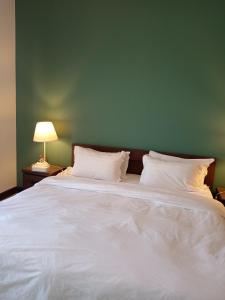 King Abdullah Economic Cityにあるجوهرة أبراج المارينا Jawhara Al Marinaの緑の壁のベッドルーム1室(白い大型ベッド1台付)