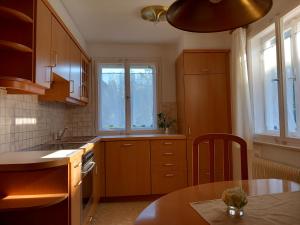 a kitchen with wooden cabinets and a table and a sink at Large house with large garden in Lauterach