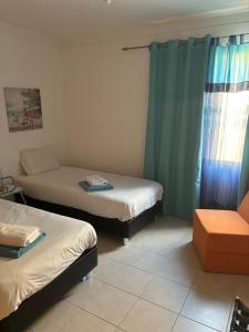 a room with two beds and a couch at casa de praia Nunes Village in Porto Santo