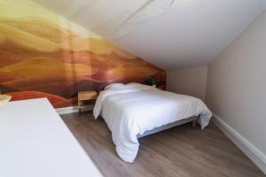 una camera da letto con un letto e un dipinto sul muro di Le Petit Verger, cosy 5 people a Vivonne