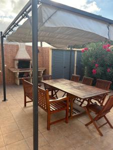 a wooden table and chairs under an umbrella on a patio at casa de praia Nunes Village in Porto Santo +19 photos