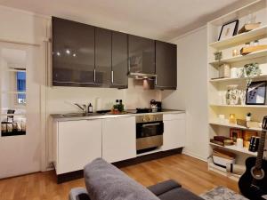 a kitchen with white cabinets and stainless steel appliances at Cozy condo near Bryggen Full kitchen Elevator in Bergen