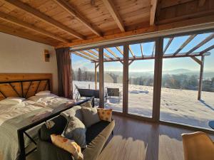 ein Schlafzimmer mit einem Bett und einem großen Fenster in der Unterkunft Widokowe Stodoły Bieszczady - domy z panoramą połonin in Lesko
