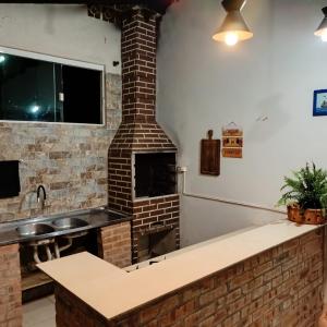 a kitchen with a brick fireplace and a sink at Palmenhaus in Pomerode +42 photos
