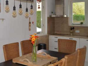 a kitchen with a table with a vase of flowers on it at Holiday Home in Quiet Park for Families in Wemeldinge