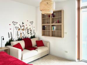 a living room with a white couch with red pillows at One Apartments NordOne Iulius Town in Timişoara