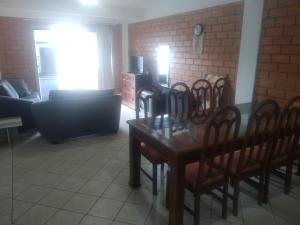 ペーニャにあるCasa na Praia Pertinho do marのダイニングテーブルと椅子のあるリビングルーム +1枚の写真