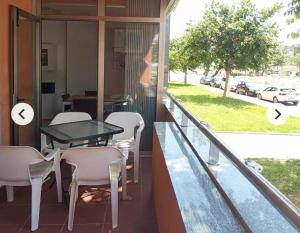 a woman standing on a balcony with a table and chairs at Algaida oropesa in Oropesa del Mar