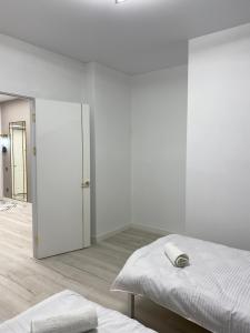 a white room with a bed and a sliding door at Шикарный Гостевой Guest Аpartments MURAGER in Astana
