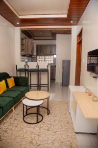 un soggiorno con un divano verde e un tavolo di La Perle de Ville a Kigali