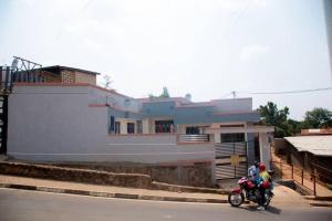 due persone in moto davanti a una casa di La Perle de Ville a Kigali