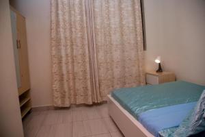 una piccola camera da letto con un letto e una finestra di La Perle de Ville a Kigali