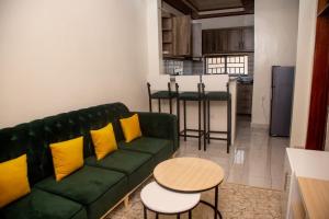 un soggiorno con divano verde e cuscini gialli di La Perle de Ville a Kigali