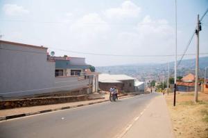 una persona che guida una moto lungo una strada di La Perle de Ville a Kigali Altre 16 foto