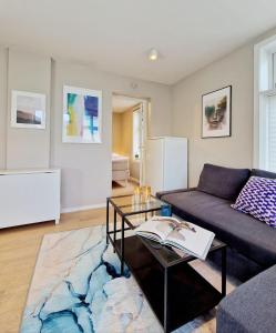 a living room with a couch and a table at Sleep well in Cozy hideout - Bryggen across the bay in Bergen
