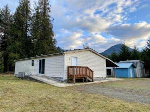 a large white building with a porch and a bench at Little Woods Outpost in Packwood