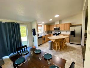 a kitchen with a dining table and a kitchen with a refrigerator at Little Woods Outpost in Packwood