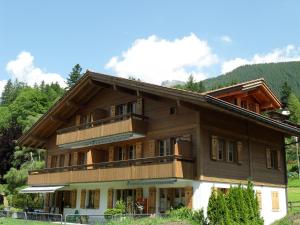 ein großes Holzhaus mit Balkon in der Unterkunft Apartment Bärhag - GRIWA RENT AG in Grindelwald