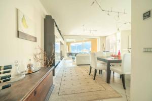 a dining room and living room with a table and chairs at Italian Lake Getaway in Maccagno Superiore
