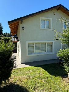 una casa blanca con dos ventanas y un patio en Rincón del Angel, en San Carlos de Bariloche