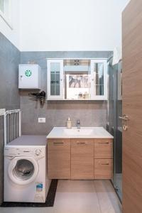 a bathroom with a washing machine and a sink at La Casa de Papel in Como