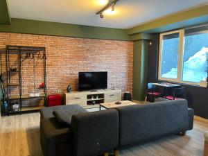 a living room with a couch and a brick wall at Mickitos Cozy Studio Two in Mavrovo