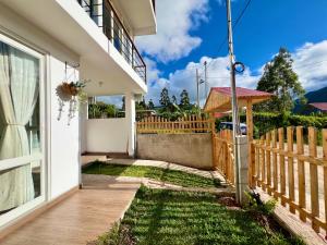 a house with a wooden fence and a yard at Colina Haus, hospedaje Oxapampa in Oxapampa