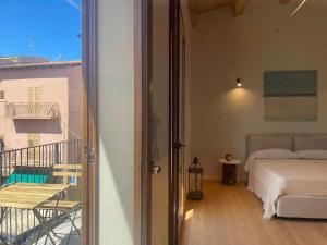 a bedroom with a bed and a balcony at Casa faro in Realmonte