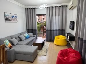 a living room with a gray couch and a window at Blue Bay Asia El Sokhna Aqua Park in Ain Sokhna