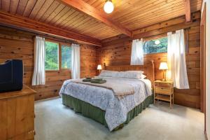 a bedroom with a bed in a log cabin at Trails End | Hot Tub, Starlink, Woodstove in Packwood