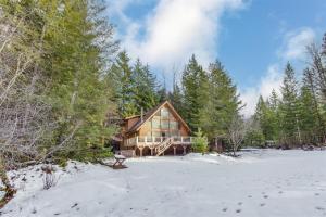 a large log cabin in the snow with trees at Trails End | Hot Tub, Starlink, Woodstove in Packwood